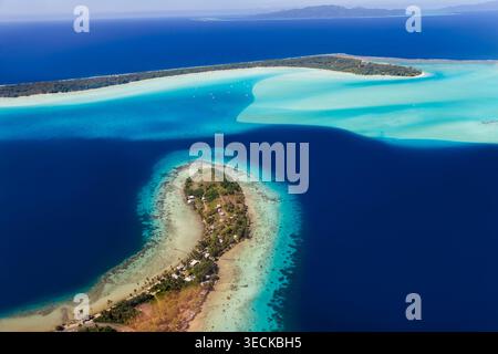 Luftpanorama der Lagune Bora Bora, Französisch-Polynesien, mit türkisfarbenen Untiefen, Korallenriffen und tiefblauem Ozean rund um eine kleine tropische Insel und Stockfoto
