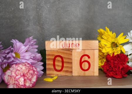 6. Juni. Holzkalender mit frischen Blumen. Kopierbereich. Stockfoto
