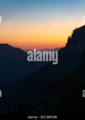 Das Licht des Sonnenuntergangs leuchtet über den mehrschichtigen Bergrücken von Leura in den Blue Mountains, NSW, und schafft eine ruhige und stimmungsvolle australische Landschaft. Stockfoto