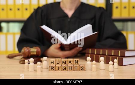 Richter und hölzerne Persönlichkeiten diskutieren die Bedeutung und Bedeutung der Menschenrechte in einem Gerichtssaal voller Themen für Gerechtigkeit und Gleichheit Stockfoto