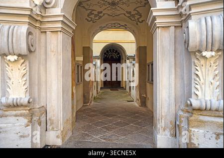 Blick durch eine dekorative barocke Gewölbepassage, die zu einem Innenhof des Stifts Durnstein führt. Das Bild zeigt die komplizierte Stockfoto