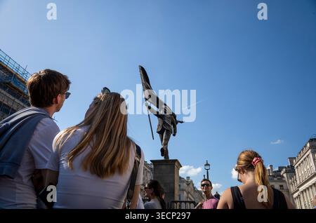 Banksy bestätigt die neuesten Kunstwerke im Waterloo Place, Westminster, England, Großbritannien Touristen treffen sich unter der satirischen Statue, die einen Mann zeigt, der von einem Abgrund marschiert, während er von einer massiven Flagge geblendet wird, die vor dem Athenaeum Club am Waterloo Place im Zentrum Londons erschien. Mai 2026 Credit: Jeff Gilbert/Alamy Live News Stockfoto