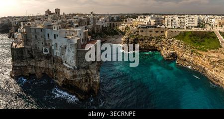 Vogelperspektive auf die bezaubernde Stadt Polignano a Mare am Morgen. Die zerklüfteten Klippen werden von klassischen weißen Gebäuden gekrönt. Polignano A Mare, Apulien Stockfoto