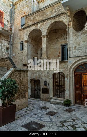 Im historischen Zentrum verbergen enge Gassen und enge Plätze alte Steinbauten mit Bögen und Loggien. Vico Porto Raguseo. Polignano A Mare Stockfoto