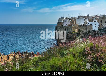 Die weiß getünchten und steinernen Gebäude von Polignano a Mare, hoch oben auf steilen Klippen mit Blick auf das türkisfarbene Wasser der Adria. Apulien Stockfoto
