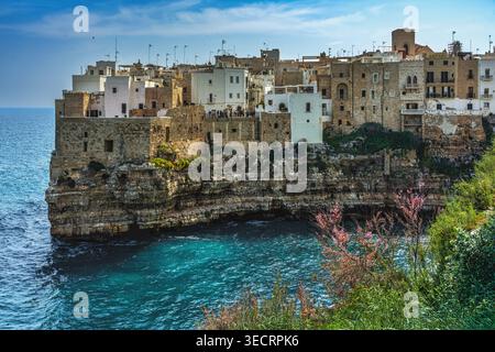 Die weiß getünchten und steinernen Gebäude von Polignano a Mare, hoch oben auf steilen Klippen mit Blick auf das türkisfarbene Wasser der Adria. Apulien Stockfoto