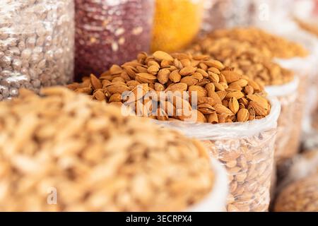 Ganze Mandeln in Hülle, ausgestellt in Massensäcken auf dem Siab Basar in Samarkand. Verschiedene Nüsse, Samen und Hülsenfrüchte zum Verkauf an einem traditionellen Marktstand. Stockfoto