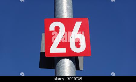 Nummer 26 rotes Schild auf dem Pfosten gegen den blauen Himmel Stockfoto