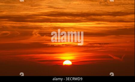 Ein atemberaubender Sonnenuntergang erfüllt den Himmel mit leuchtenden goldenen Tönen, die einen warmen Glanz über den Horizont werfen. Die beschauliche Szene fängt das Wesen des Gols ein Stockfoto