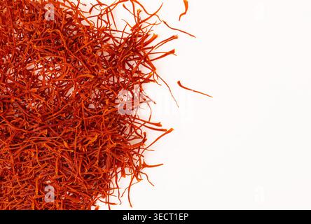 Safranfäden schaffen eine lebhafte rote und orangene Textur auf weißem Hintergrund Stockfoto