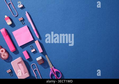 Pop-Art-Komposition von pinkfarbenen Schulmaterialien auf blauem Hintergrund, einschließlich Schere, Clips, Stifte und Notizen; Konzept für Back to School for Generation Stockfoto