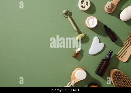 Eine Sammlung umweltfreundlicher, abfallfreier Schönheitsprodukte auf grüner Oberfläche, die nachhaltige und natürliche Kosmetik, einschließlich Bürsten, Flaschen, Stockfoto