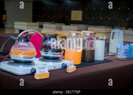 Hotel-Buffet-Selbstbedienungs-Getränkestation mit thailändischem Milchtee, Kaffeekaraffen und frischen Milchkannen auf dem Tisch. Stockfoto