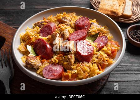 Traditionelle polnische Bigos-Mahlzeit oder Hunter's Stew mit Würstchen, Fleisch und gedünstetem Kohl aus nächster Nähe. Hausgemachtes geschmortes Sauerkraut mit Bratwurst. Stockfoto