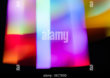 Leuchtende, farbenfrohe Lichtstreifen mit weichem Bewegungsunschärfe. Futuristische Regenbogenverlaufslinien erzeugen einen dynamischen Rhythmus und ein Gefühl von Geschwindigkeit auf dunklem Hintergrund. Stockfoto