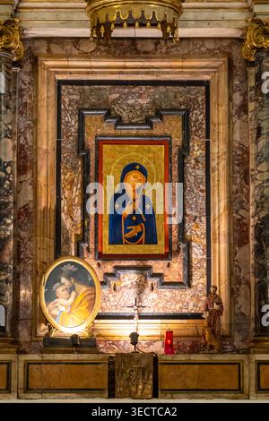 Byzantinische Illustration der Jungfrau Maria, die an einer Marmorwand in der Mitte des Altars in der historischen Kirche in Rom hängt Stockfoto