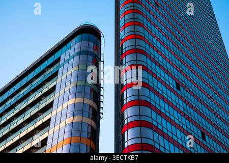 Flacher Blick auf leuchtende rote und gelbe Glasfassaden unter klarer Abendbeleuchtung Stockfoto