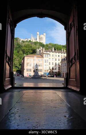 Blick auf die Basilika Notre-Dame de Fourvière durch die offenen Türen der Kathedrale Saint-Jean-Baptiste, Place Saint-Jean, Vieux Lyon, Frankreich. Stockfoto