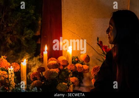 Eine mexikanische Frau besucht das Grab ihrer Eltern während der Feierlichkeiten zum Tag der Toten in San Andrés Mixquic, Mexiko. Stockfoto