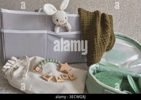Babypflegeartikel und Spielzeug für Neugeborene in einer grau gestreiften Organizer-Tasche, die Gesundheit und Wellness fördert Stockfoto