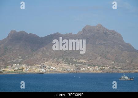 Westafrika, Kap Verde, Sao Vicente, Porto Grande. Blick auf die Küste von Mindelo Bay mit Face Mountain in der Ferne. Stockfoto