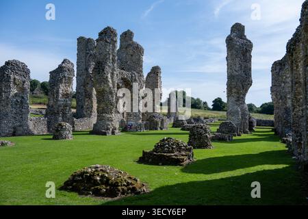Stein- und Feuersteinsäulen und Mauerruinen im offenen Innenhof von Castle Acre Priory, Castle Acre, Norfolk, England, Vereinigtes Königreich. Stockfoto