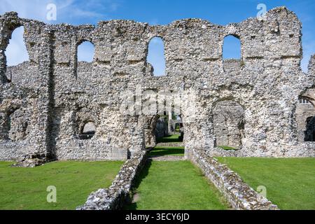 Steinmauer mit mehreren Öffnungen und einem zentralen Bogengang in den Ruinen von Castle Acre Priory, Castle Acre, Norfolk, England, Vereinigtes Königreich. Stockfoto