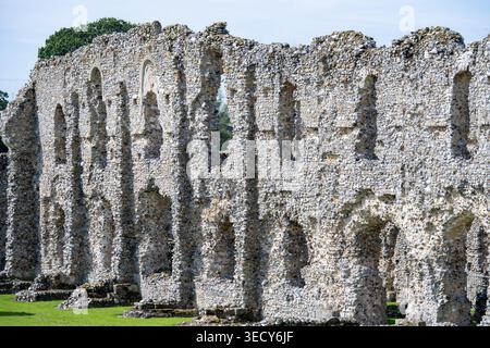 Blick aus der Nähe auf die verwitterte Feuersteinsteinmauer mit bogenförmigen Öffnungen in den Ruinen der Castle Acre Priory, Castle Acre, Norfolk, England, Großbritannien. Stockfoto