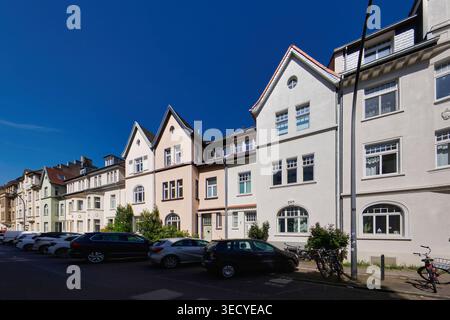 Eine Reihe gepflegter, historischer Wohnhäuser unter hellblauem Himmel in Köln-Ehrenfeld. Städtischer Architekturstil Stockfoto