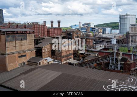 Blick auf Völklingen mit Kirchtürmen, Bahnlinien und Industriegebäuden aus der Völklinger Hütte im Saarland. Stockfoto
