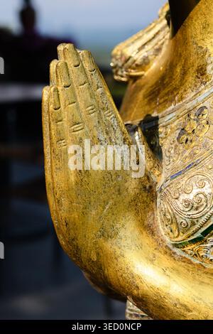 Nahaufnahme der Hände einer goldenen Buddha-Statue mit zusammengepressten Palmen als Ausdruck des Friedens und der Ehrfurcht vor Gott. Stockfoto