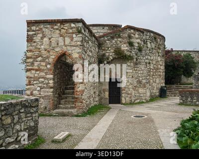 Eingang Aus Antikem Steinbau Mit Bogenförmiger Treppe Und Eisentor, Brescia, Italien. Stockfoto