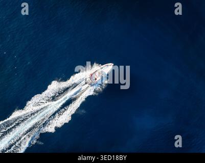Aus der Vogelperspektive eines RIPPBOOTES, das das blaue Meer mit Geschwindigkeit überquert Stockfoto
