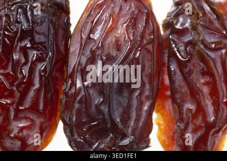 Drei getrocknete Datteln, die Textur und Farbe zeigen. Stockfoto