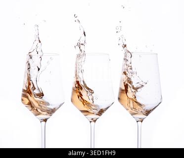 Wasserspritzer aus drei Weingläsern in einer Studioszene Stockfoto