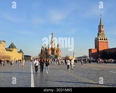 Blick auf den Roten Platz an einem sonnigen Tag mit Basilius-Kathedrale, KAUGUMMI und Glockenturm im Hintergrund; Menschen gehen auf dem Platz in Moskau, Russland Stockfoto