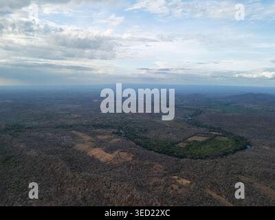 Die Luftaufnahme zeigt am späten Nachmittag einen sich windenden Fluss, der von Hügeln umgeben ist, unter einem teilweise bewölkten Himmel. Stockfoto