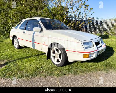 Nahaufnahme eines klassischen weißen Ford Sierra auf einem Grasfeld mit Scheinwerfern und Stoßfängern Stockfoto