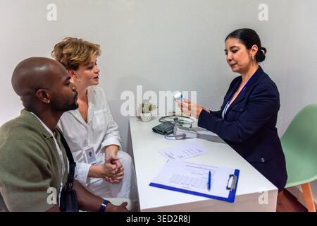 Arzt erklärt Rezept für verschiedene Patientenpaare Stockfoto