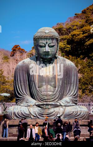 Besucher treffen sich unter dem Großen Buddha von Kamakura im Kotoku-in Tempel in Hase, Japan. Stockfoto