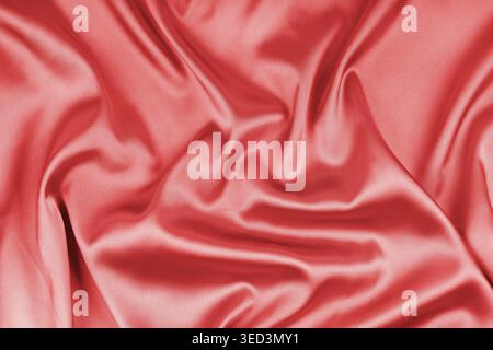 Zerknitterte, zerknitterte rote glänzende Seidensatin-Textur. Glänzender glatter Stoff mit weichen Falten, Stoff mit Wellenvorhang. Eleganter und satter Hintergrund, W Stockfoto