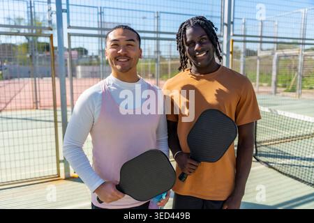 Verschiedene Freunde genießen Pickleball auf dem Platz im Freien Stockfoto