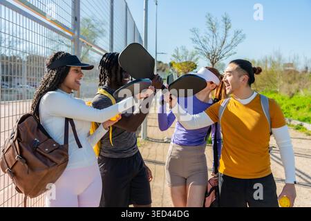 Verschiedene Freunde jubeln beim Pickleball auf dem Platz im Freien Stockfoto
