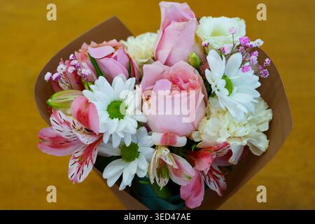 Schönes Blumenbouquet verpackt und bereit zum Verschenken in hellen Farben Stockfoto