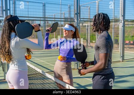 Verschiedene Freunde genießen das Pickleball-Spiel auf dem Platz im Freien Stockfoto