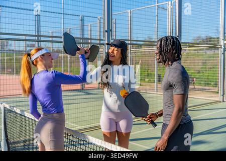 Verschiedene Freunde genießen das Pickleball-Spiel auf dem Platz Stockfoto