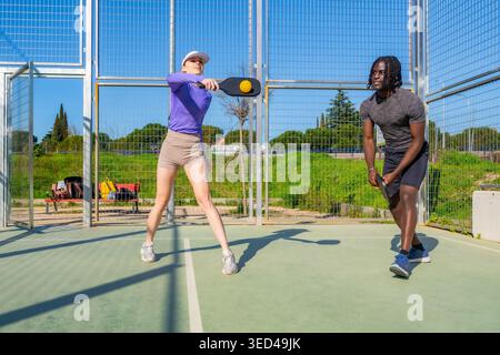 Diverse Paare spielen Pickleball auf dem Platz im Freien Stockfoto