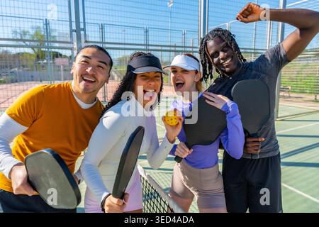 Verschiedene Freunde genießen Pickleball auf dem Platz im Freien Stockfoto