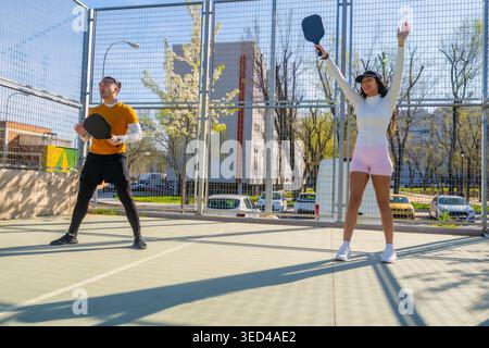 Verschiedene Freunde spielen aktiv Pickleball-Spiel auf dem Platz im Freien Stockfoto