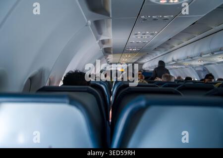 Die Weitwinkelansicht des Innenraums erfasst die komplette Kabine eines modernen Passagierflugzeugs mit langen Sitzreihen. Stockfoto